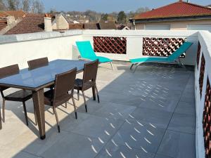un patio con una mesa azul y sillas en la azotea en Gîte Bourbonne-les-Bains, 2 pièces, 2 personnes - FR-1-611-97, en Bourbonne-les-Bains