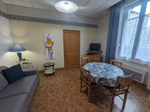 波旁莱班Appartement 3 étoiles tout confort, près des thermes, avec toit-terrasse ensoleillé à Bourbonne-les-Bains - FR-1-611-97的客厅里有一张沙发和一张桌子。