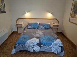 1 dormitorio con 1 cama con colcha azul y blanca en Gîte Bourbonne-les-Bains, 2 pièces, 2 personnes - FR-1-611-97, en Bourbonne-les-Bains