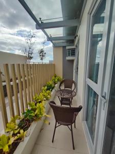 a balcony with two chairs and plants on it at The Verdin at Maple Grove in Cavite