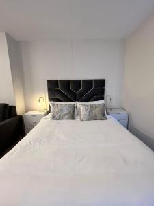 a bedroom with a large white bed with two pillows at The Millennial Umhlanga in Durban +2 photos
