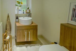 a bathroom with a sink on a wooden cabinet at Heskyn Mill Cottage in Saint Germans