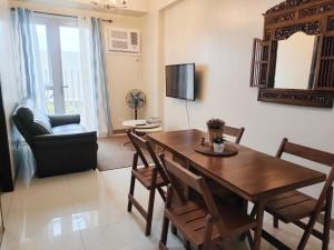 a living room with a dining room table and chairs at The Verdin at Maple Grove in Cavite
