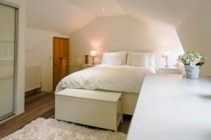 um quarto com uma cama branca e 2 candeeiros em Heskyn Mill Cottage em Saint Germans