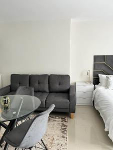 a living room with a couch and a table and a bed at 135 on Millennial Umhlanga in Durban