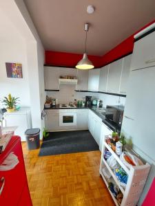 a kitchen with white cabinets and a red ceiling at Wonderful stay Monet in Ghent