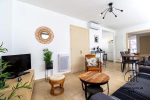 a living room with a couch and a tv at Au cœur des Lices in Albi