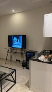 a living room with a flat screen tv on a wall at Narcissus suite in Riyadh