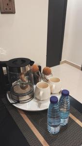 a plate with a food processor and some water bottles at Narcissus suite in Riyadh