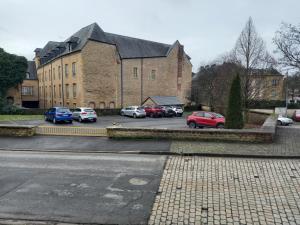 ein Parkplatz mit Autos vor einem Gebäude in der Unterkunft le Fort de Bayle in Sedan