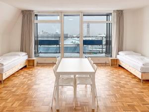 Cette chambre comprend deux lits et une table avec des chaises. dans l'établissement T&K Apartments - 2 and 3 Room Apartments - Heart of Solingen-Hofgarten, à Solingen