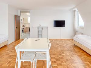a white dining room with a white table and chairs at T&K Apartments - 2 and 3 Room Apartments - Heart of Solingen-Hofgarten in Solingen