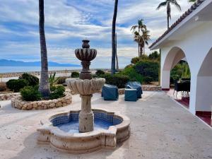 a fountain in the middle of a patio with palm trees at Rancho Las Cruces in Las Cruces