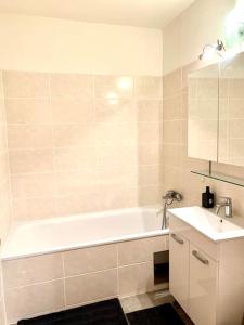 a bathroom with a white tub and a sink at Charmante Wohnung in St. Peter. in Graz