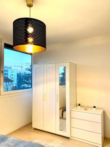 ein Schlafzimmer mit einem Spiegel und einem Kronleuchter in der Unterkunft Charmante Wohnung in St. Peter. in Graz