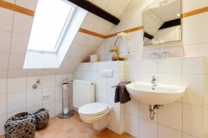 a bathroom with a toilet and a sink at Hotel Das Kemperdick in Erkrath