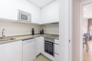 a kitchen with white cabinets and a microwave at MALDONADO II in Madrid