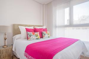 a bedroom with a large bed with pink sheets and pillows at MALDONADO II in Madrid