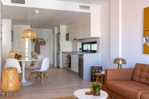 a living room and kitchen with a couch and a table at Casa Onesta Luxery apartment with private rooftop terrace in Orihuela