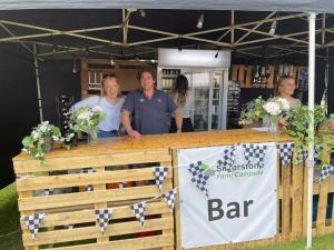 a man and a woman standing behind a bar at a book store at Silvestone Farm Campsite in Silverstone