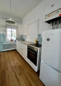 cocina con electrodomésticos blancos y nevera blanca en Ferienhaus in Wilster / Monteure, 