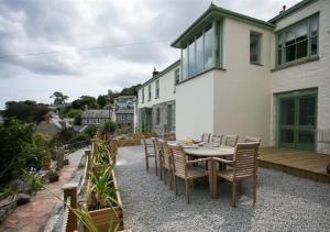 a patio with a table and chairs and a house at Orchard Cottage in Newlyn