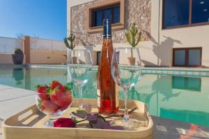 a tray with two wine glasses and a bowl of strawberries at Villa Campo Sol in Ibiza Town