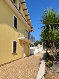 Casa amarilla con balcón y palmera en La casa di Chloe, en Torrevecchia Teatina