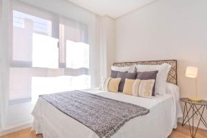 a white bedroom with a bed with two pillows at MALDONADO I in Madrid