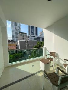 balcón con sillas y vistas a la ciudad en Miami Hotel Cartagena - Luxury Apartments, en Cartagena de Indias
