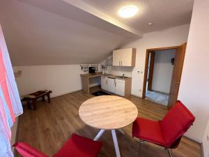 a small kitchen with a table and red chairs at Entspannungsoase Haus Iris in Kirchham