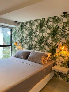 una camera da letto con un grande letto e carta da parati tropicale di Hotel 14-04 a Cali