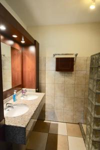 a bathroom with two sinks and a shower at Blue Bay Beach Villas & Apartments in Blue Bay