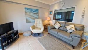 a living room with a couch and a chair and a television at Redcliffe Apartments J in Bishopston
