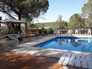 einen Pool mit einer Bank und einem Sonnenschirm in der Unterkunft El Estudio in Cardenete