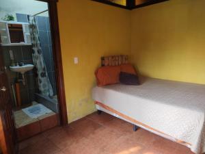 a small bedroom with a bed and a shower at Hosteria del Centro in Santiago Atitlán