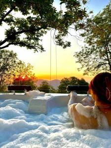 Una donna in una vasca idromassaggio con dentro dei pupazzi di neve di Ahşap villa a Tepecik