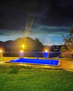 una piscina blu in un parco di notte di Ahşap villa a Tepecik