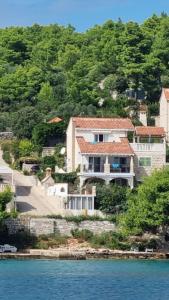 a large house on a hill next to the water at LOFT direkt am Meer mit grosser Terrasse in Lumbarda