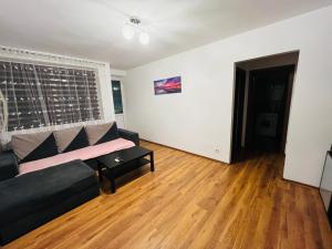 a living room with a black couch and a table at Apartament Soseaua Stefan cel mare in Bucharest +2 photos