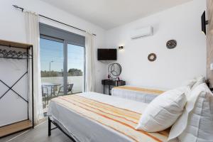 a bedroom with two beds and a balcony at Villa Livis 2 in Kiotari +27 photos