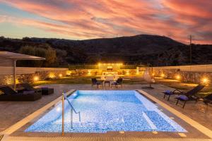 a swimming pool in a yard with a sunset at Villa Livis 2 in Kiotari