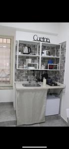 eine Küche mit einer Spüle und einer Arbeitsplatte in der Unterkunft riccia, frolla e babbà in Neapel