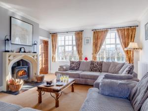 a living room with a couch and a fireplace at 7 bed in Exford MONKH in Exford