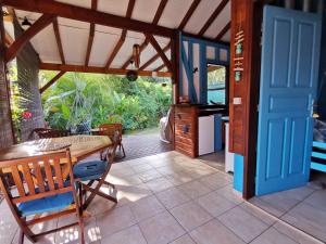 a dining room with a table and a blue door at Blue Kaz Caraïb in Pointe-Noire
