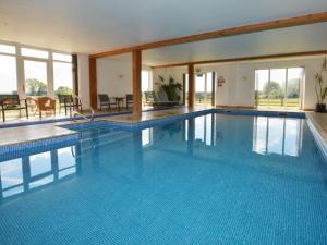 a large swimming pool with blue tiles in a building at 2 Bed in Sherborne FOLWO in Long Burton