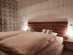 a bedroom with two beds and a wooden headboard at Old Town Apartment, Free Parking in Liptovský Mikuláš
