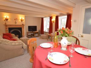 a living room with a table with a red table cloth at 3 bed in Rock STMIN in Saint Minver