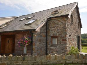 a small brick house with a flower basket on it at 2 Bed in Gower 40481 in Dunvant