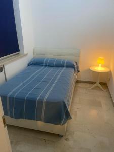 a bedroom with a bed and a table with a lamp at Casa di Anna in Ravenna